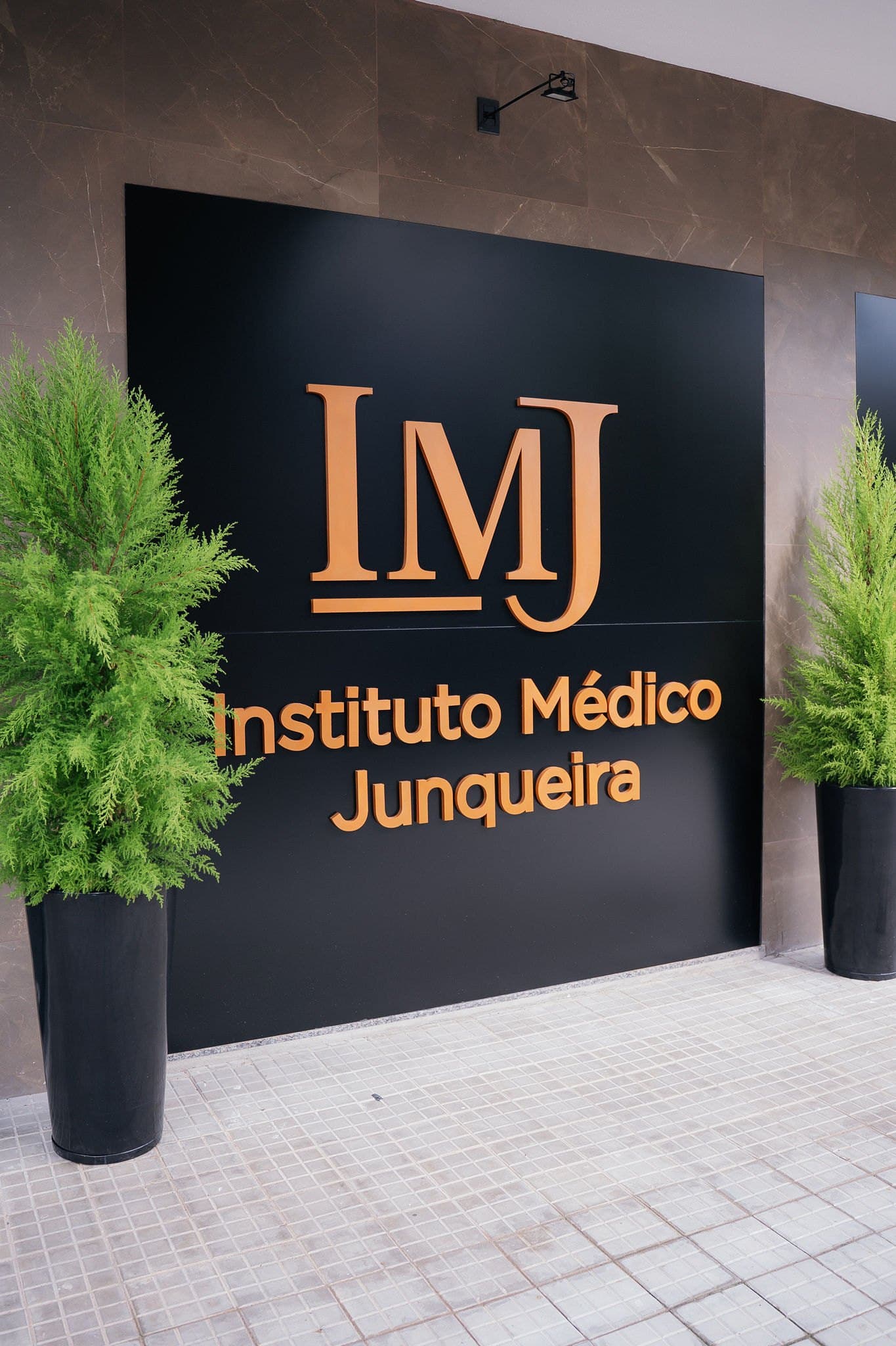Parede de entrada do Instituto Médico Junqueira com letras douradas
